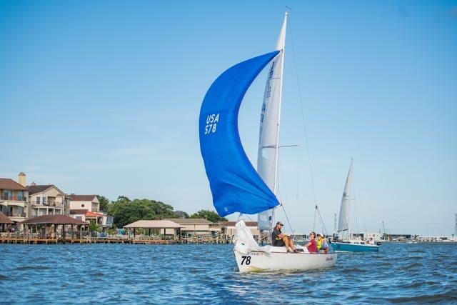 A sailboat racing with a blue spinnaker on Clear Lake, TX