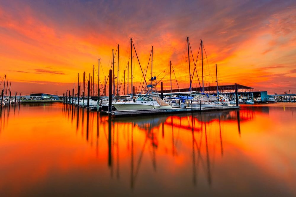 Sailboats moored at a marina in Seabrook, TX at sunset