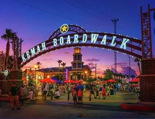The Kemah Boardwalk entrance sign lit up at dusk